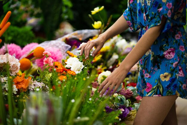 Foto recortada de uma mulher comprando plantas em uma floricultura cheia de diferentes baldes de flores