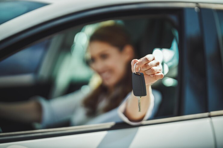 Foto foto recortada de uma mulher segurando as chaves de seu carro novo. foco seletivo. foco na chave.