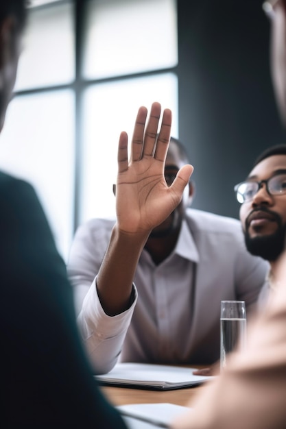 Foto recortada de uma pessoa levantando a mão durante uma reunião no trabalho