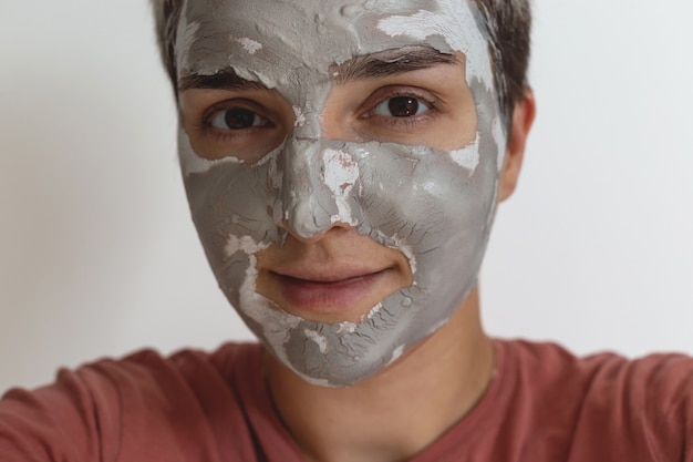 Foto recortada de mujer aplicar mascarilla de arcilla verde gris para el cuidado de la piel en la cara rutina diaria de cuidado de la piel de belleza