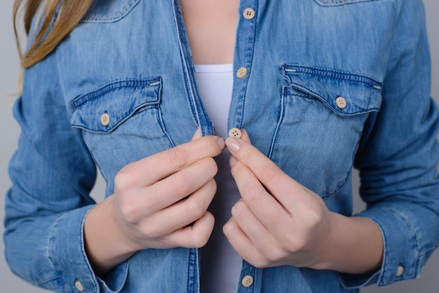 Foto recortada de mujer en camisa de jeans con botones