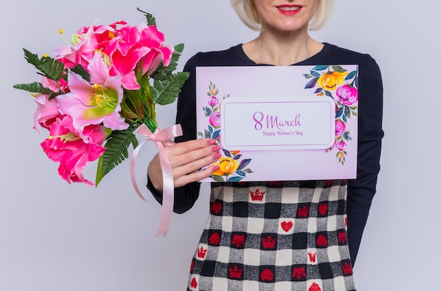 Foto foto recortada de mujer joven sosteniendo una tarjeta de felicitación y un ramo de flores