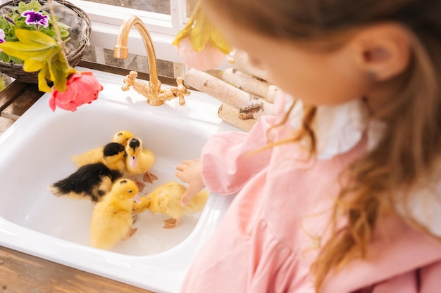 Una foto recortada de una niña adorable irreconocible en un hermoso vestido jugando con un lindo amarillo