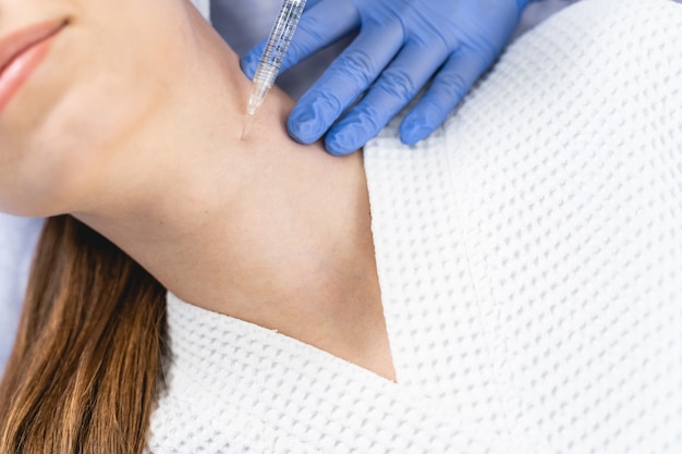 Foto recortada de una paciente joven sometida a un tratamiento de mesoterapia en un salón de belleza