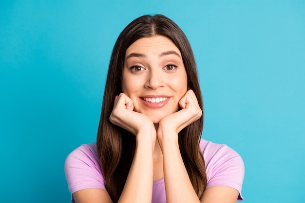 Foto retrato de alegre joven lagy vestida con traje violeta casual brazos mejillas fondo de color azul aislado