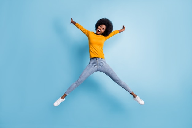 Foto retrato de cuerpo completo de mujer saltando extendiéndose como estrella aislada sobre fondo de color azul pastel