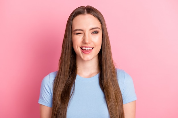 Foto retrato de menina piscando isolado em um fundo de cor rosa pastel