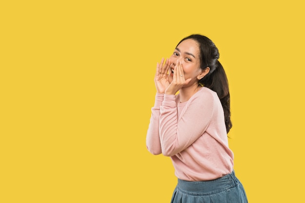 Foto retrato de mujer gritando sosteniendo dos manos cerca de la boca