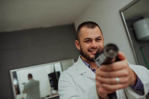 Foto de retrato de un peluquero loco con un secador de pelo en la mano Foto de alta calidad