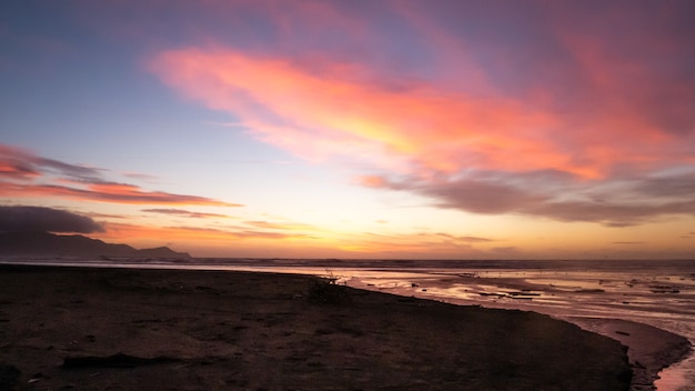 Foto roxa do pôr do sol na praia da costa de Kapiti