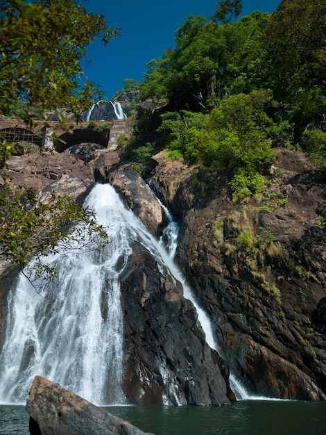 Foto schöner hoher Wasserfall auf dem Goa in der Nähe von vorbeifahrenden Zügen