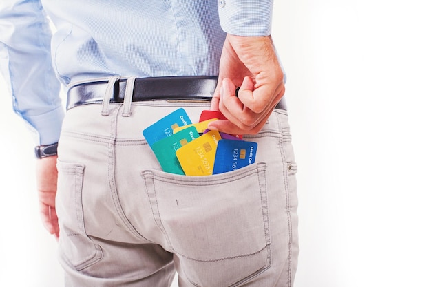 Foto sem rosto de um homem tirando muitos cartões de crédito do bolso, isolado no fundo branco