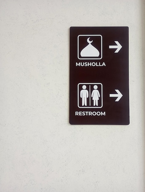 Foto de señales direccionales para la sala de oración y el baño