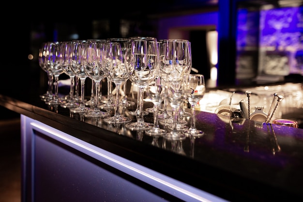 Foto de un soporte de copas de vino de discoteca en la barra en colores fluorescentes