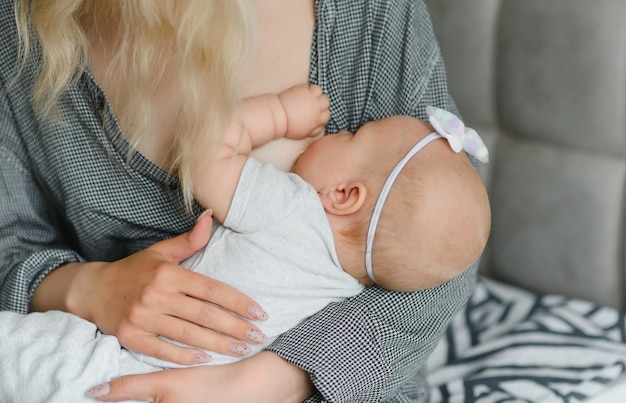 Foto suave joven madre amamantando a su bebé en casa