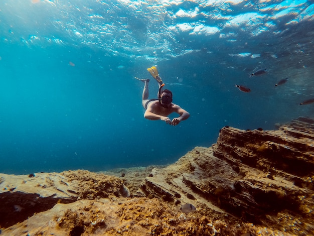 Foto subaquática de homens mergulhador mergulhar na água do mar