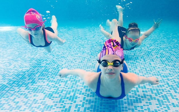 Foto subaquática de jovens amigos na piscina.