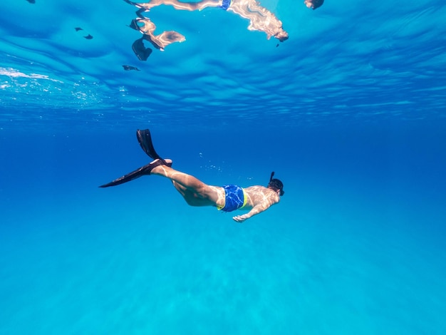 Foto submarina freediver nadar en mar claro