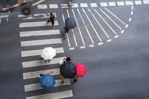 La foto superior vista aérea de la gente camina en la calle en la ciudad sobre el camino del tráfico del paso de peatones