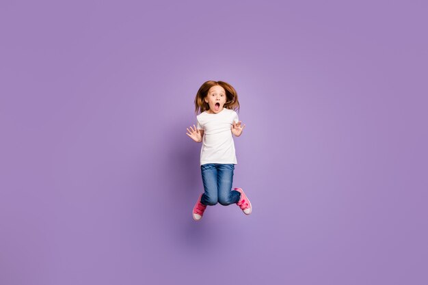 Foto de tamaño completo de una pequeña dama de jengibre divertida saltando alto sin palabras