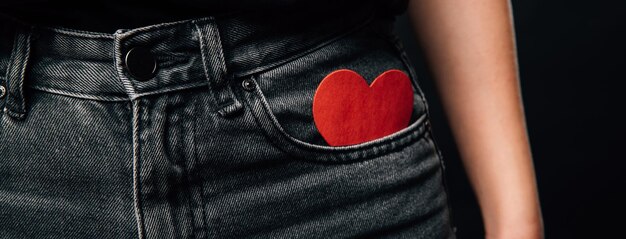 Foto tamaño pancarta de un corazón de papel rojo que se puso en un bolsillo gris de jeans