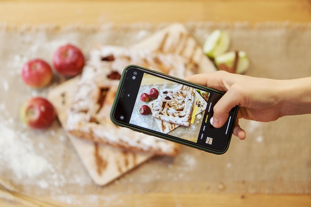 Foto en el teléfono un pastel sobre una tabla de cortar la comida está lista para comer hojaldre