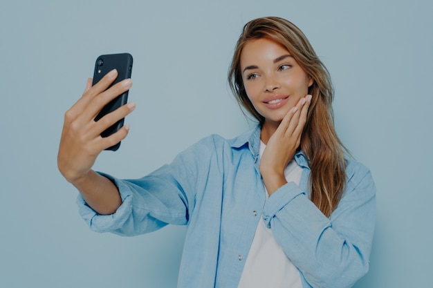 Foto de toma de mujeres jóvenes aislado sobre fondo azul claro