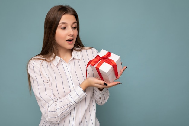 Foto tomada de bastante positivo sorprendido joven mujer rubia oscura aislada sobre fondo de colores