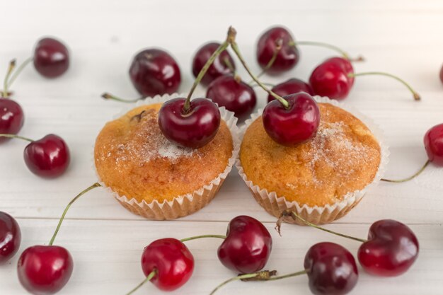 Foto tonificada de dois muffins decorados com cerejas frescas