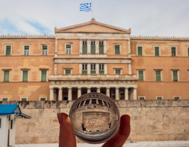 Foto a través de una bola de cristal del parlamento griego en la plaza Syntagma en Atenas Grecia
