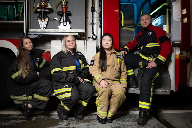 Foto de tres mujeres bombero bombero en el fondo del camión de bomberos