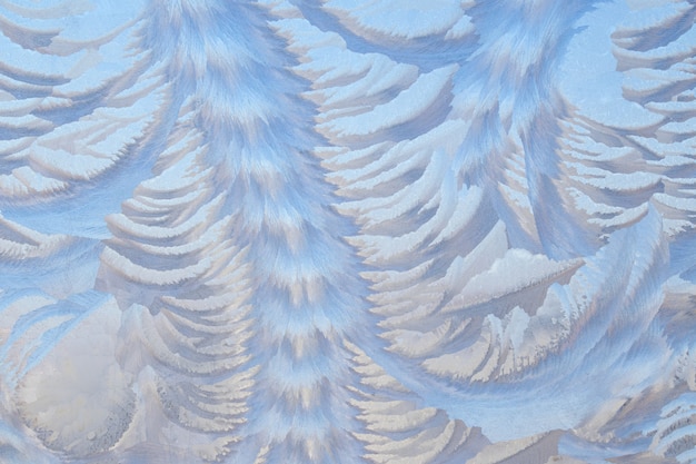 Foto de una ventana congelada. Patrones escarchados en el cristal. Fondo de hadas de invierno