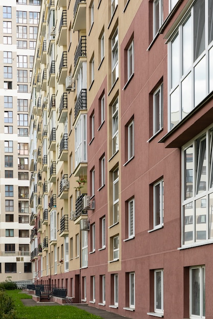 Foto vertical de la alta fachada de la casa moderna de nueva construcción, hierba en el suelo