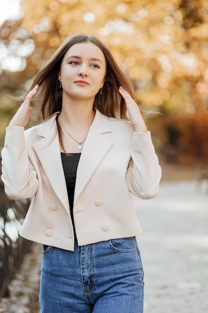 Foto vertical Bela adolescente despreocupada em roupas casuais Retrato de uma bela garota contra o fundo da natureza com um fundo desfocado