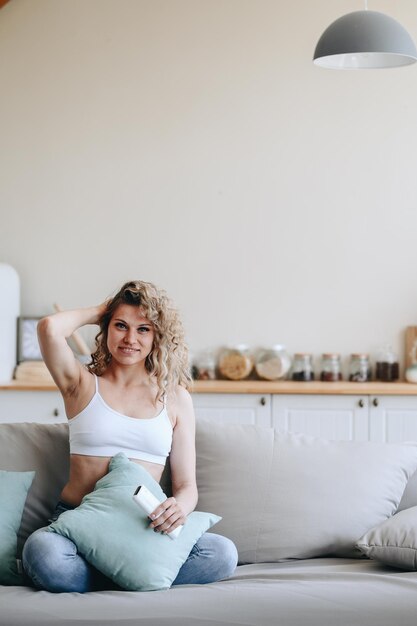 Foto foto vertical de una chica en casa en el sofá.