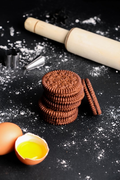 Foto foto vertical de biscoitos empilhados uns sobre os outros com um rolo de massa e quebrado, por exemplo