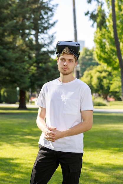 Foto vertical de jovem colocou VR na cabeça e olhando para a câmera