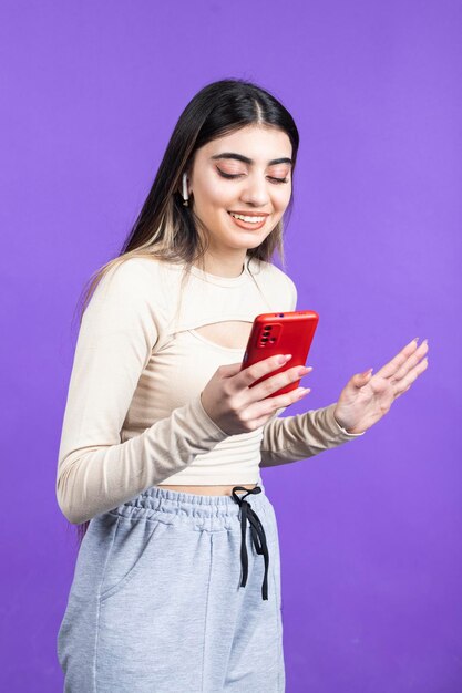 Foto vertical de jovem segurando o telefone e sorrindo Foto de alta qualidade