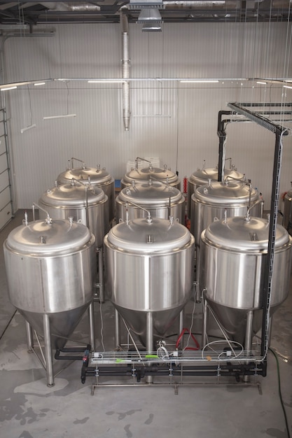 Foto vertical de tanques de cerveja e equipamentos de produção de cerveja na microcervejaria