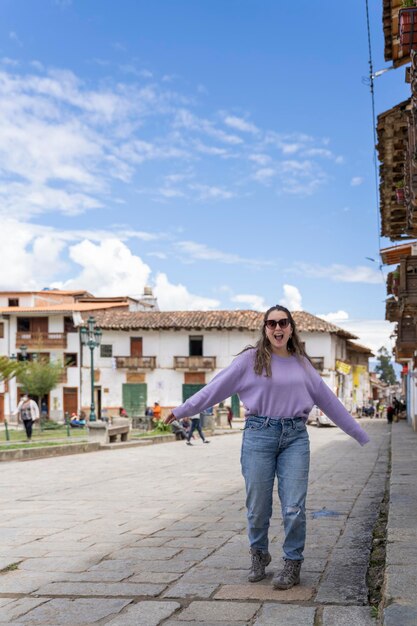 Foto vertical de uma jovem feliz na rua de uma tradicional cidade andreana