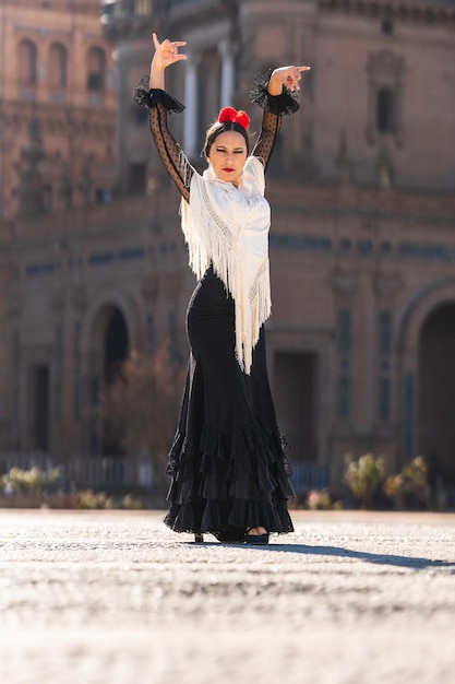 Foto vertical de uma mulher em um vestido de flamenco dançando em uma praça