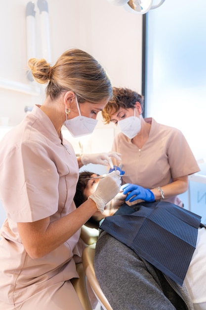 Foto vertical del dentista haciendo un examen preventivo a un hombre