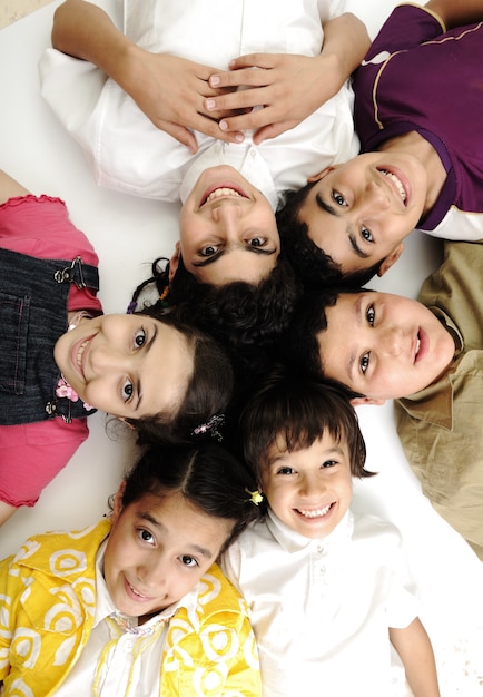 Foto vertical do grupo de crianças, amigos sorrindo isolado no branco, meninos e meninas closeup