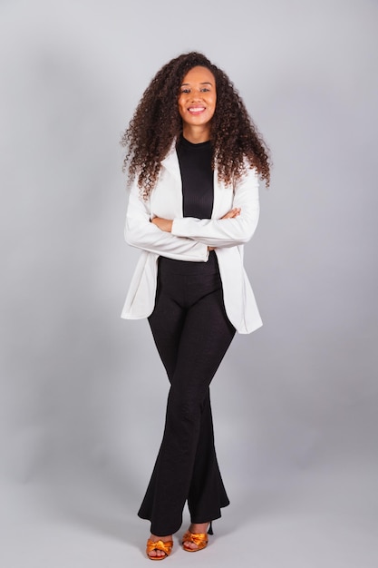 Foto vertical hermosa mujer brasileña negra empresaria con traje blanco sonriendo optimista