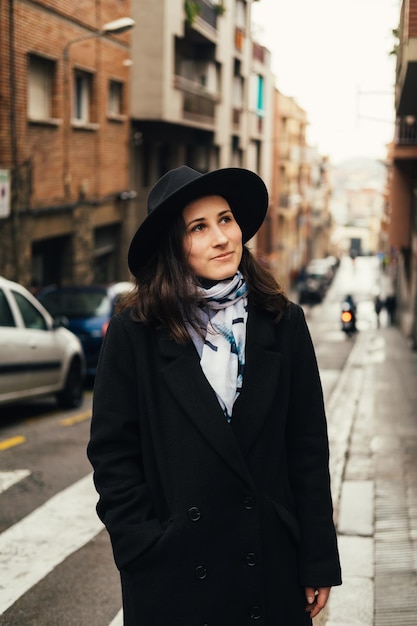 Foto vertical de una joven turista caminando y explorando la antigua ciudad europea