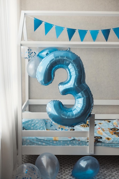 Foto vertical de una linda casa en la habitación de los niños decorada con globos azules para niños de 3 años