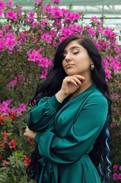 Foto vertical, menina sonhadora entre roseiras floridas. Foto de alta qualidade