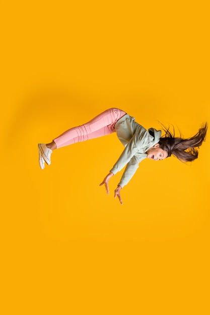 Foto vertical de perfil de la pupila volando sueño levitar gravedad aislado sobre fondo de color amarillo brillante