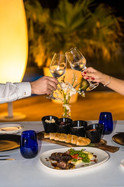 Foto foto vertical en primer plano de una pareja brindando durante una cena romántica