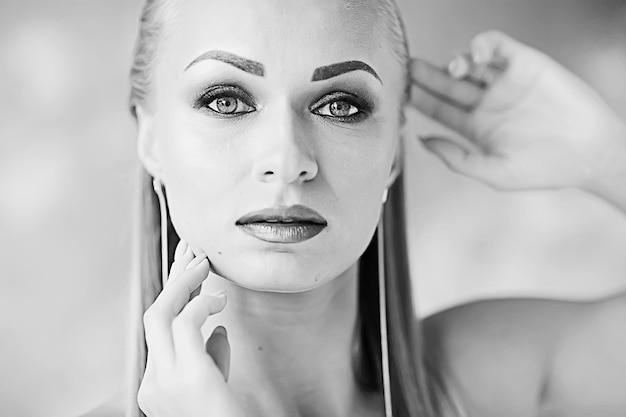 foto vintage em preto e branco de uma garota com maquiagem profissional / maquiagem rigorosa no rosto de uma bela modelo profissional em um salão de beleza